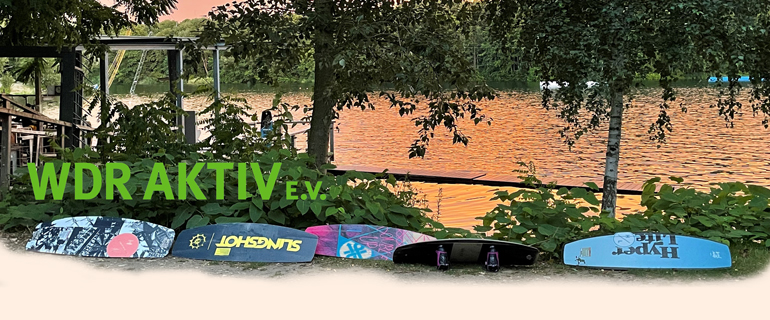Wakeboards am Ufer eines Sees, in dem sich der Sonnenuntergang spiegelt und Schriftzug 'WDR Aktiv e.V.'